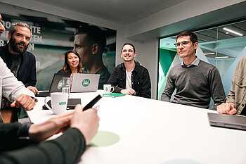 Eine Gruppe Werder-Mitarbeiter:innen sitzt in einer Konferenz.